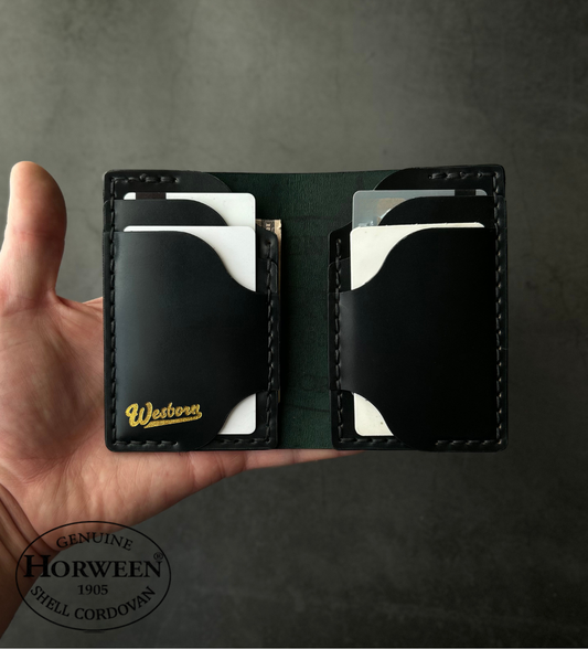 Hand holding a black leather wallet with 'Western' branding on a gray background