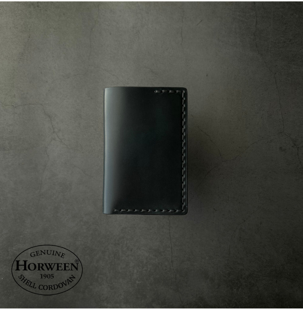Black leather wallet on a textured gray background with Horween Shell Cordovan logo.