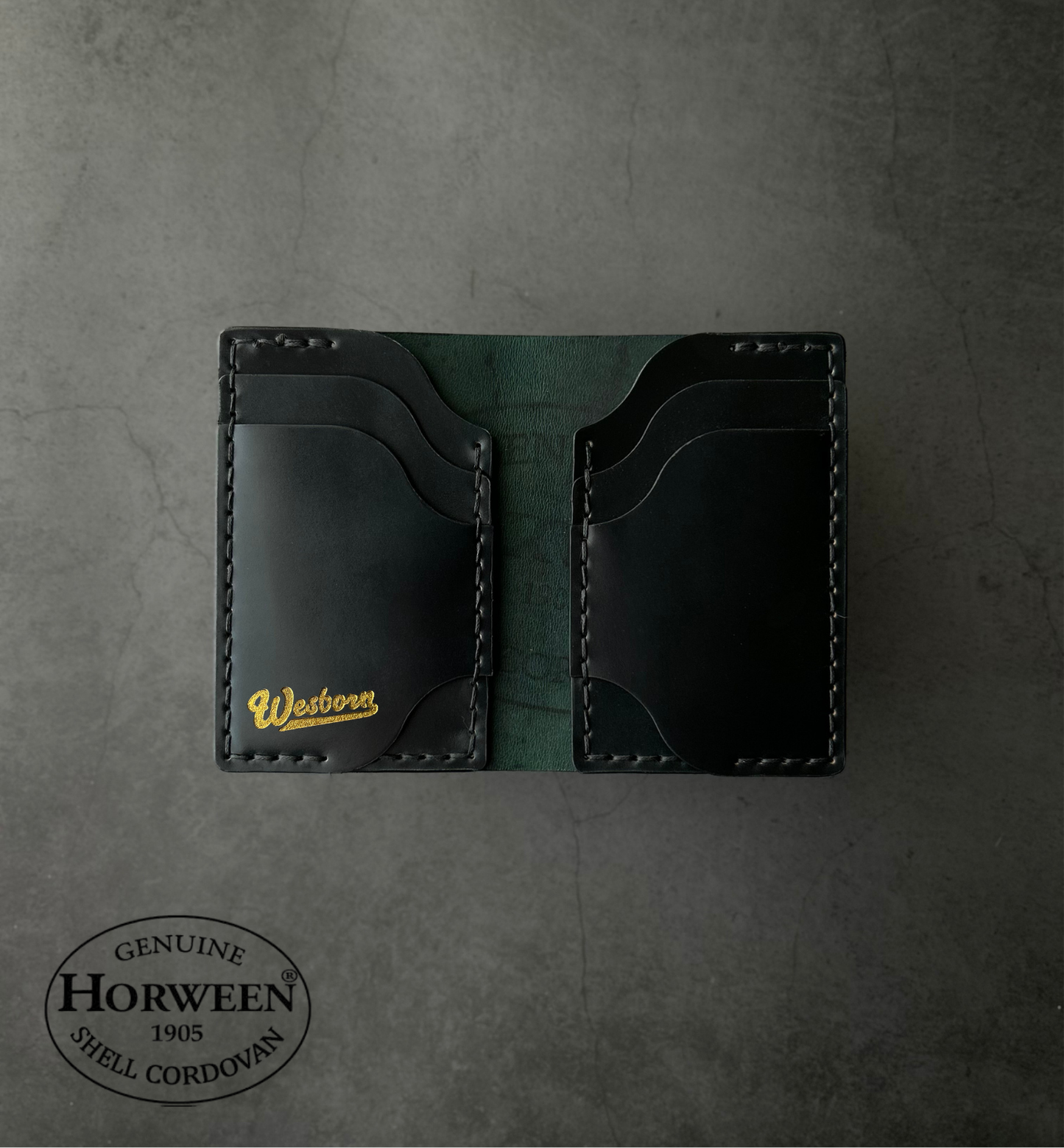 Black leather wallet with gold lettering on a gray textured background, featuring Horween Shell Cordovan branding.