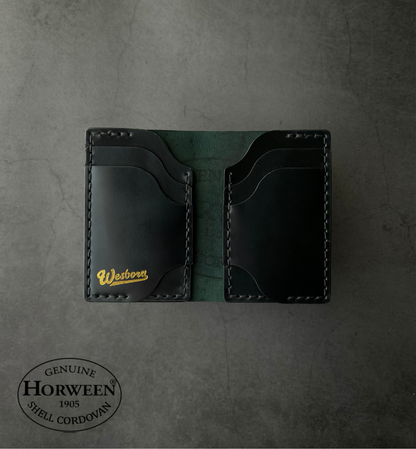 Black leather wallet with gold lettering on a gray textured background, featuring Horween Shell Cordovan branding.