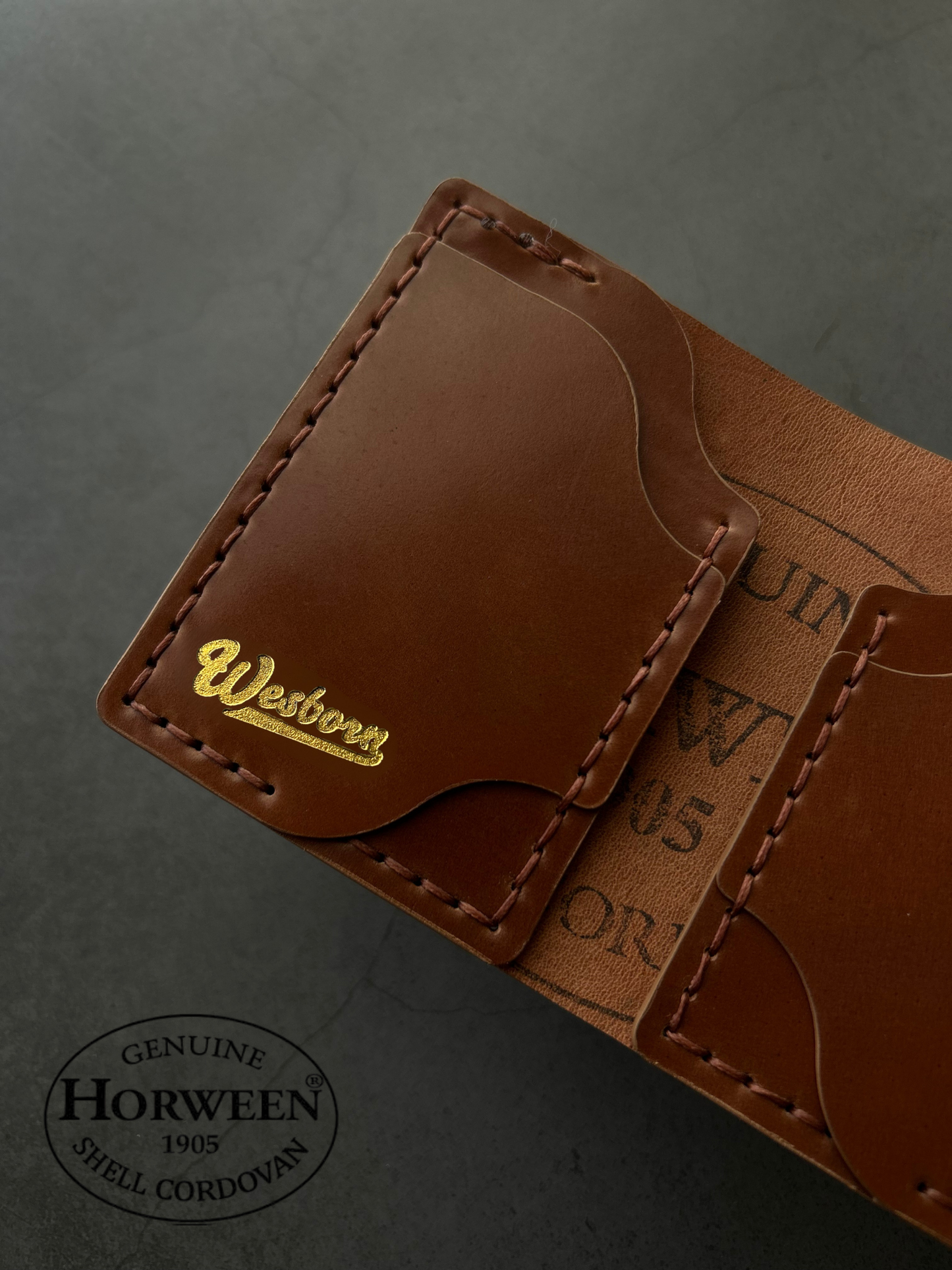 Brown leather wallet with 'Wesbourn' branding on a gray background