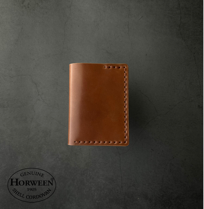 Brown leather wallet on a dark gray background with Horween logo.